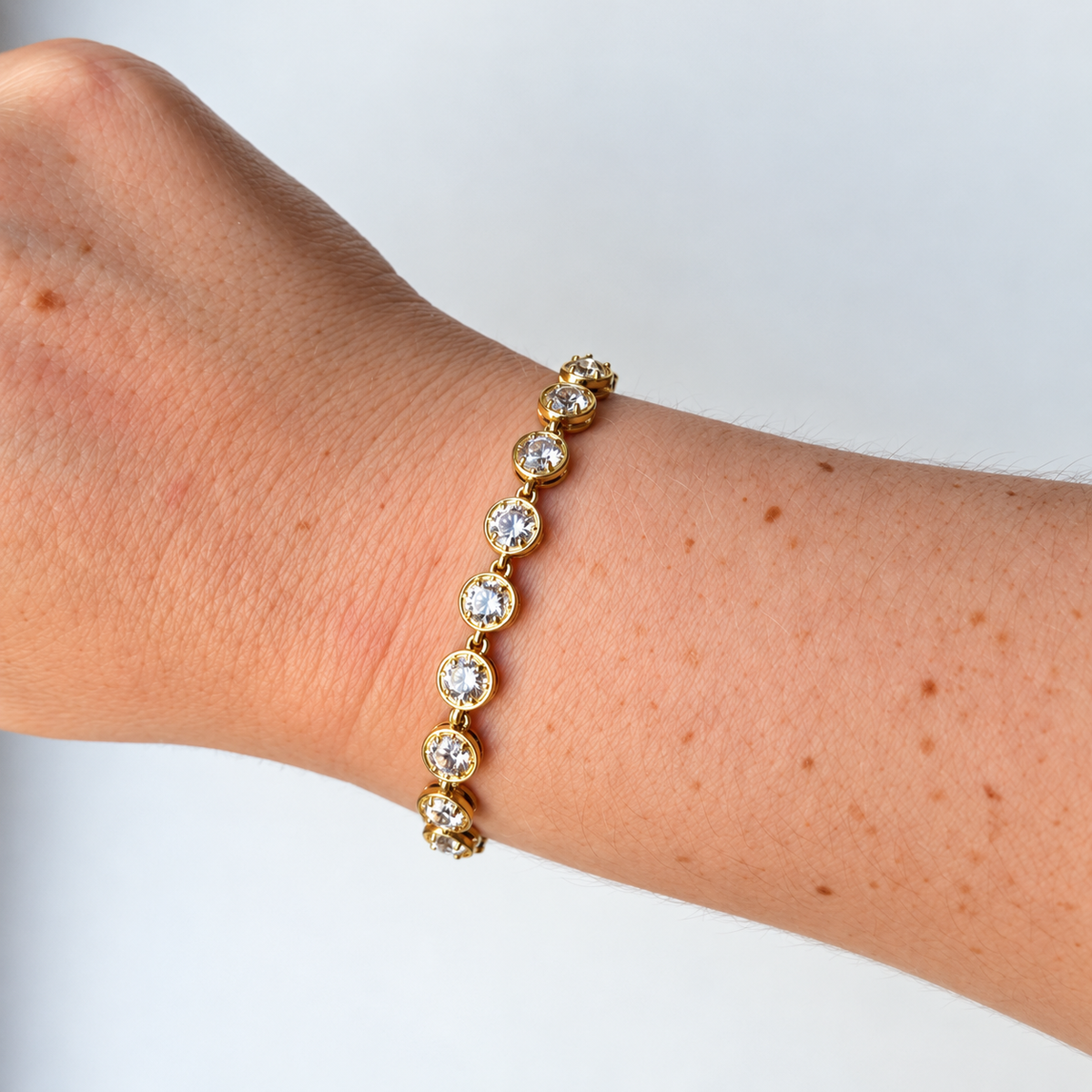 Armband met ronde steentjes – goudkleurig gedragen aan de pols