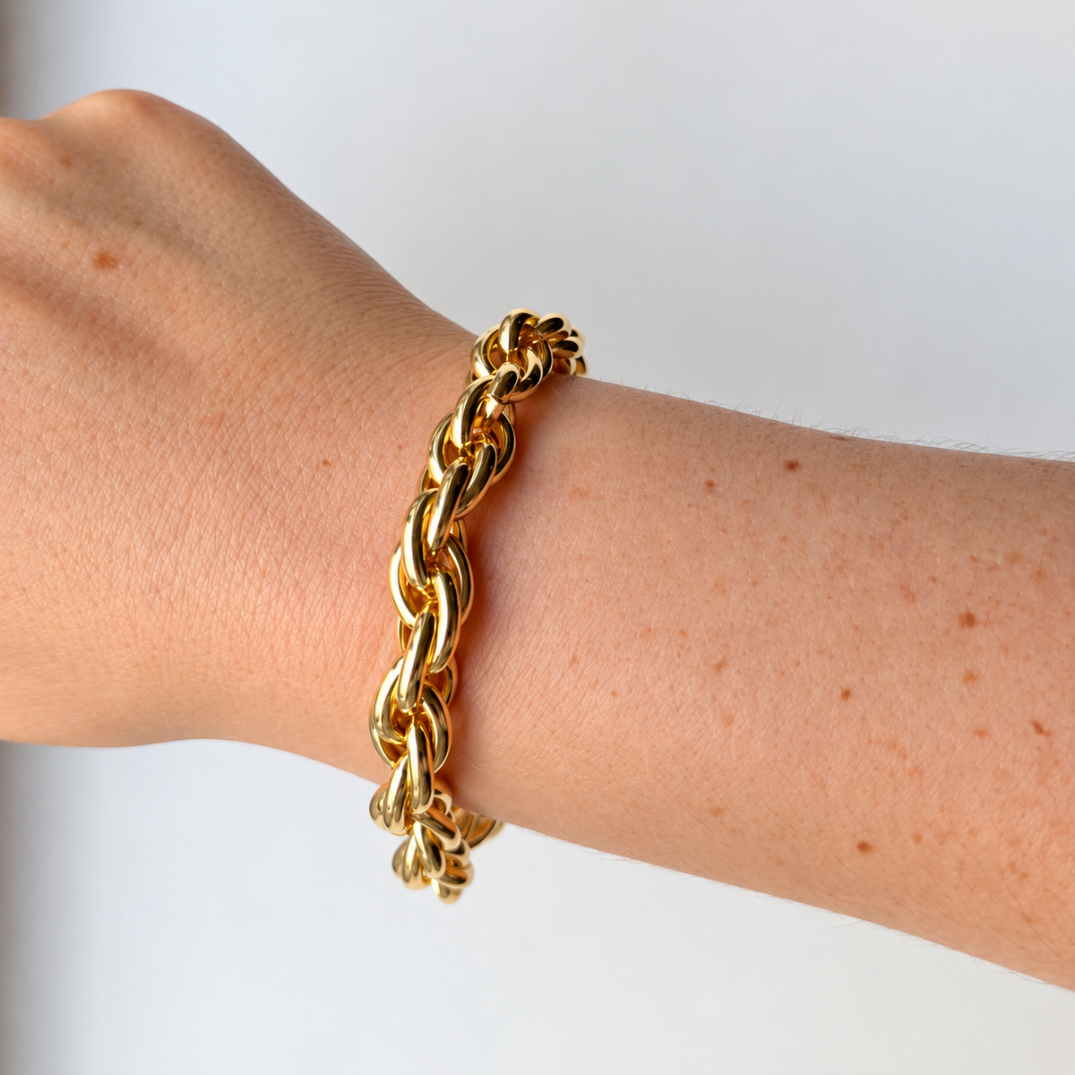 Armband met gedraaide schakels – goudkleurig gedragen aan de pols