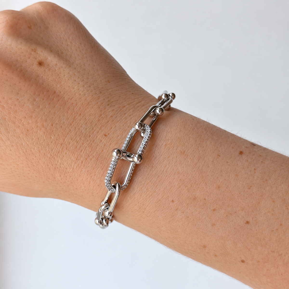 Armband met langwerpige schakels en steentjes – zilverkleurig gedragen aan de pols