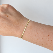 Armband met platte schakels – goudkleurig gedragen aan de pols