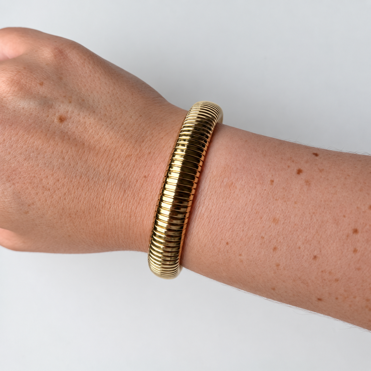 Armband met ribbels – goudkleurig gedragen aan de pols