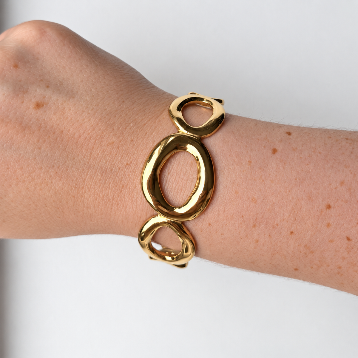 Armband met open ovalen – goudkleurig gedragen aan de pols
