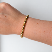 Armband met bolletjes – goudkleurig gedragen aan de pols