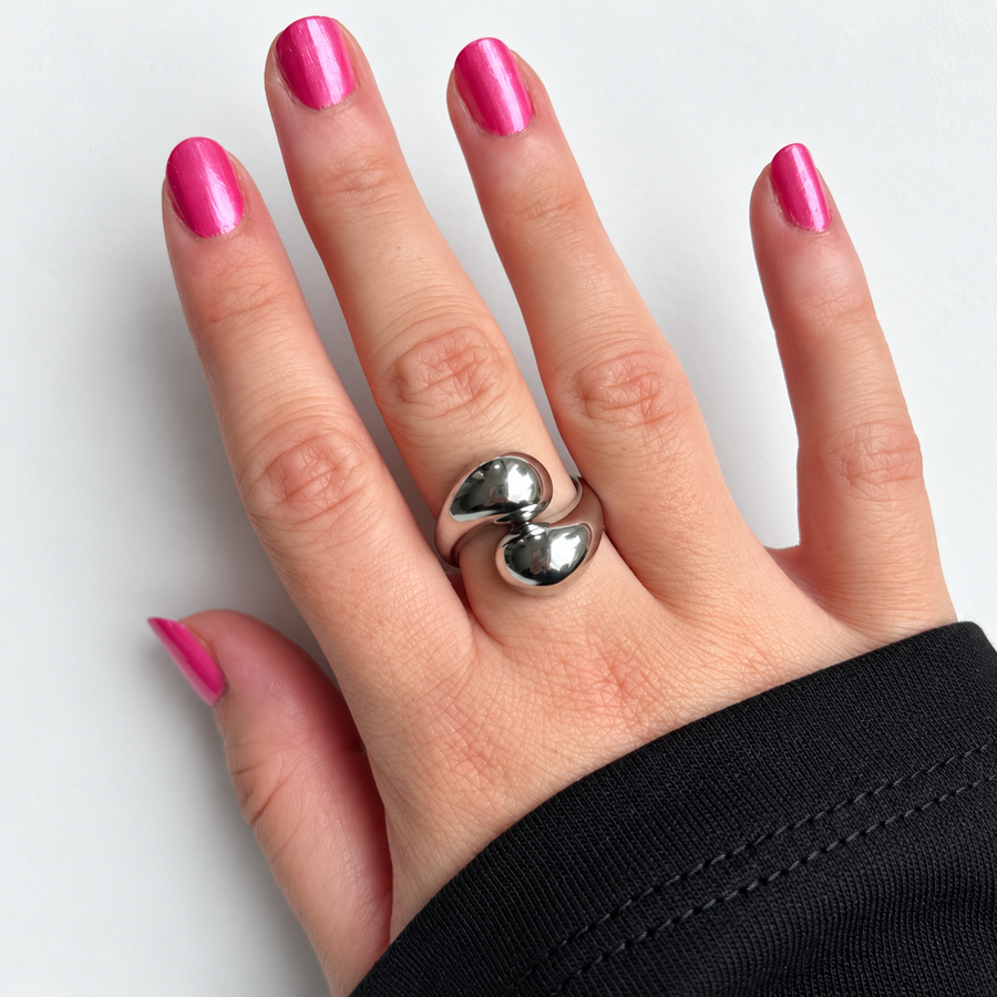 Zilverkleurige ring met dubbele druppel gedragen aan de hand