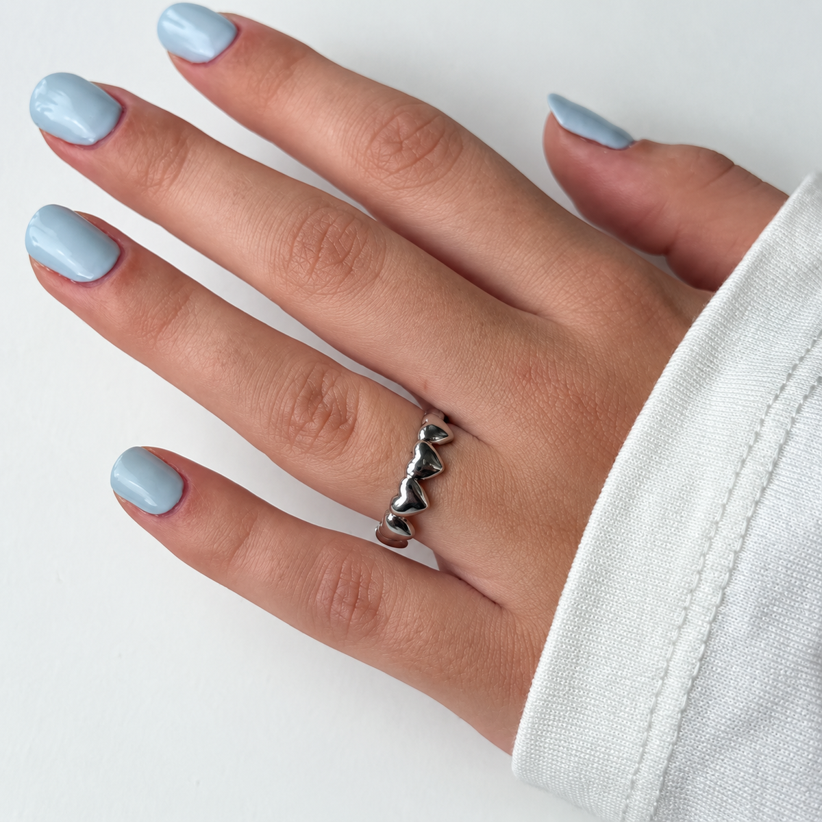 Ring met rij hartjes – zilverkleurig gedragen aan de hand