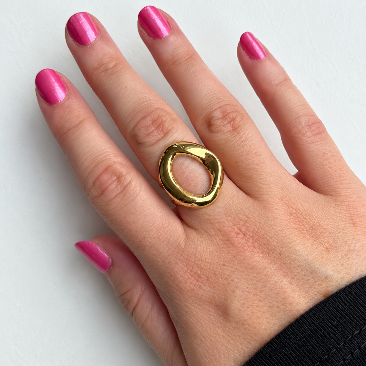 Ring met open ovale vorm – goudkleurig gedragen aan de hand