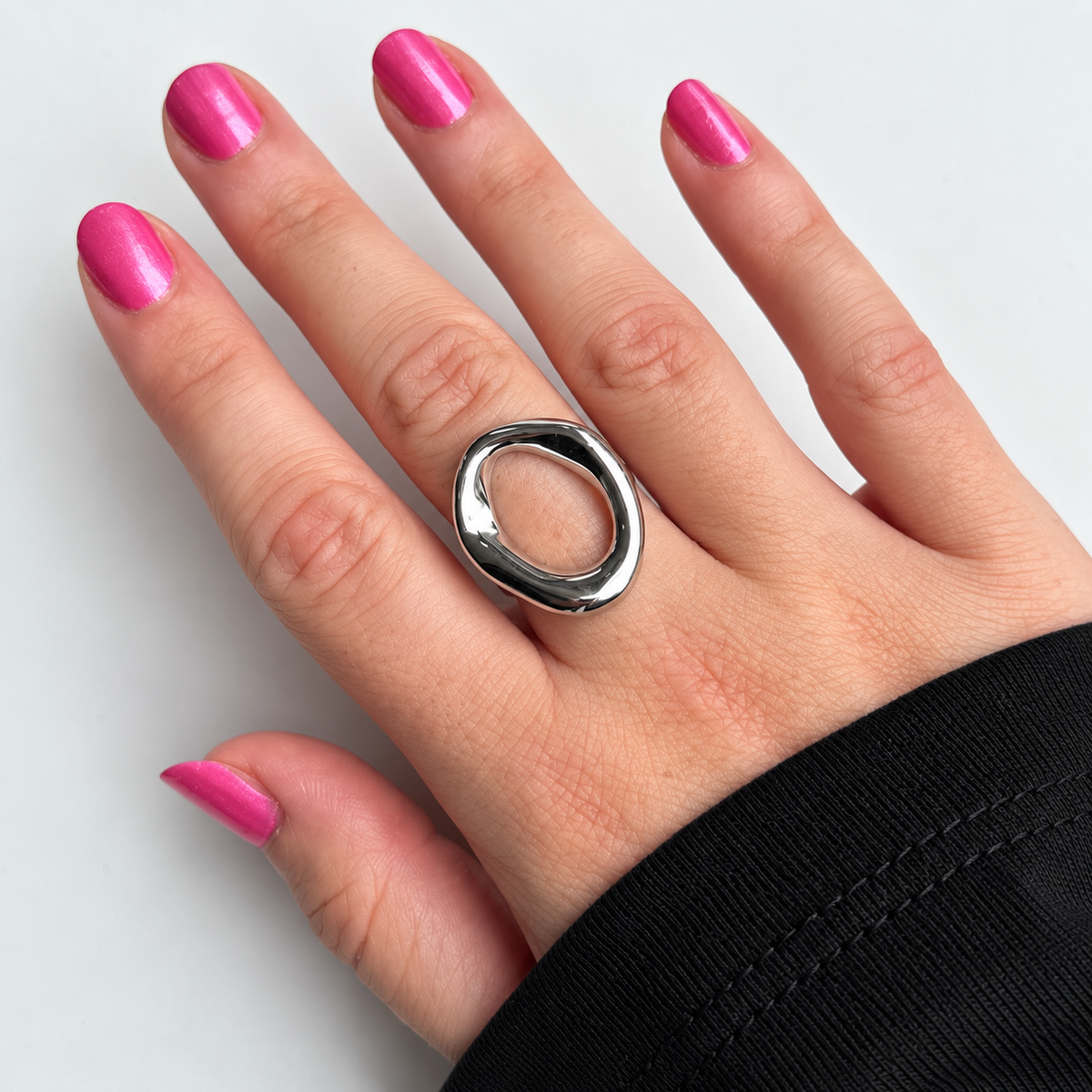 Ring met open ovale vorm – zilverkleurig gedragen aan de hand