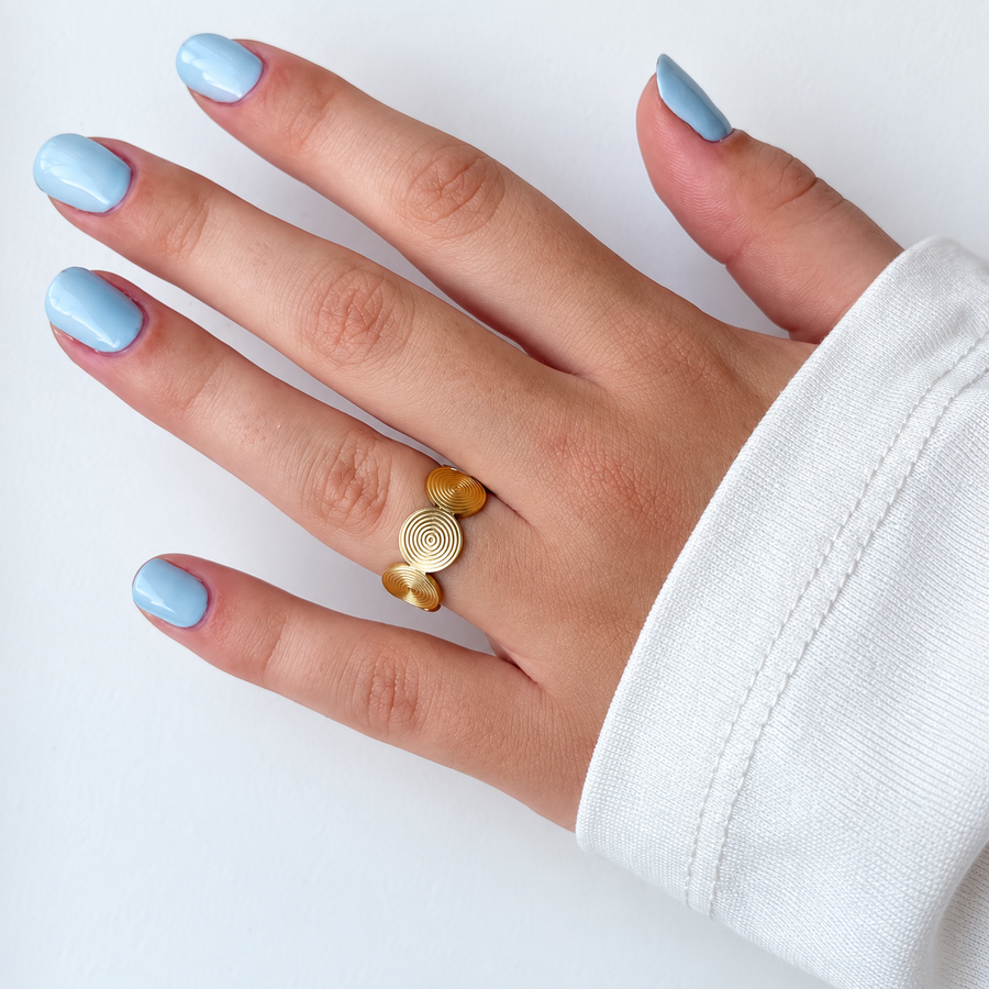 Ring met ronde spiraaldetails – goudkleurig gedragen aan de hand